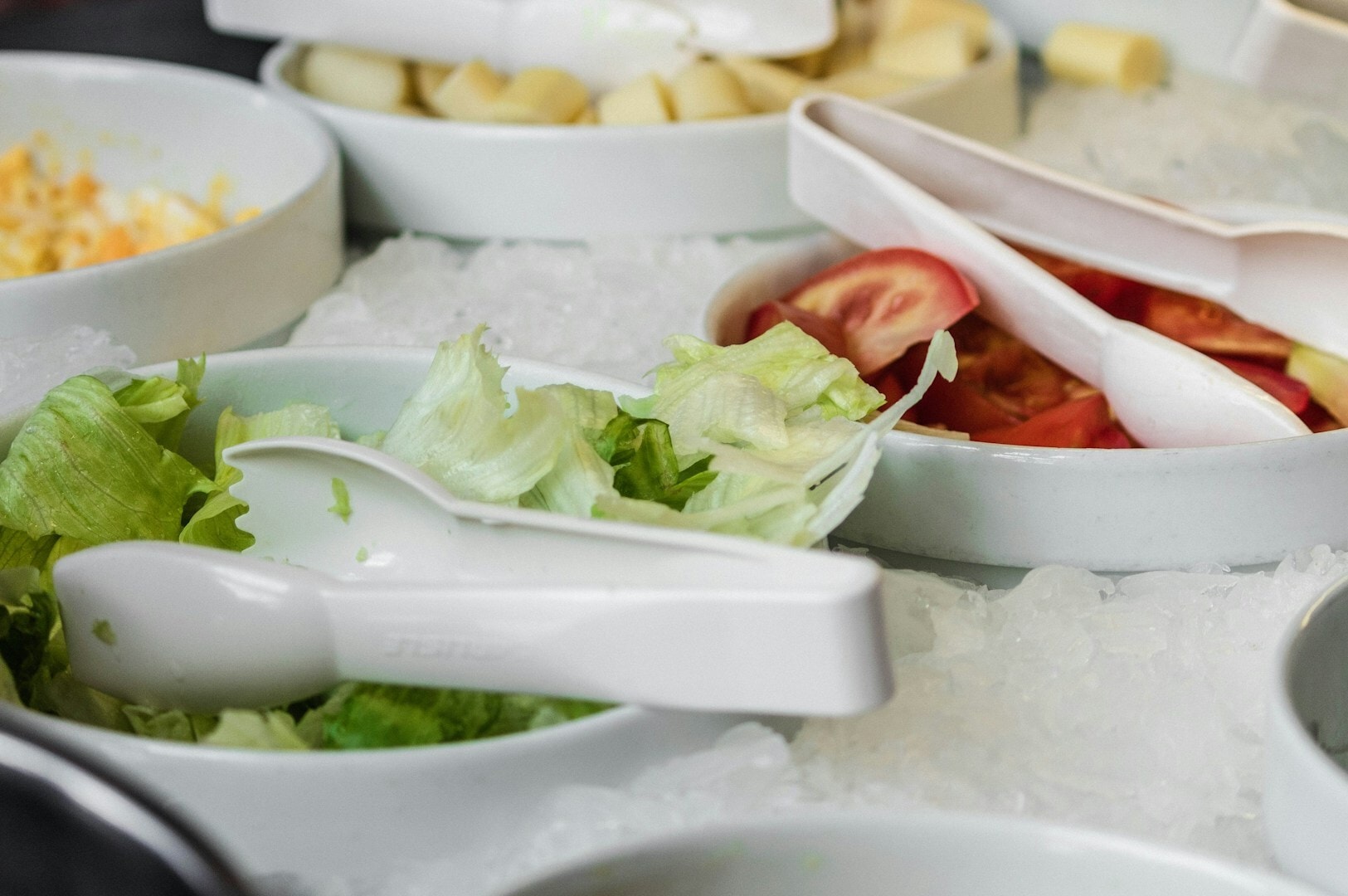 A colorful buffet spread at a Singapore Hawker Centre showcasing bowls of salads and an assortment of foods.