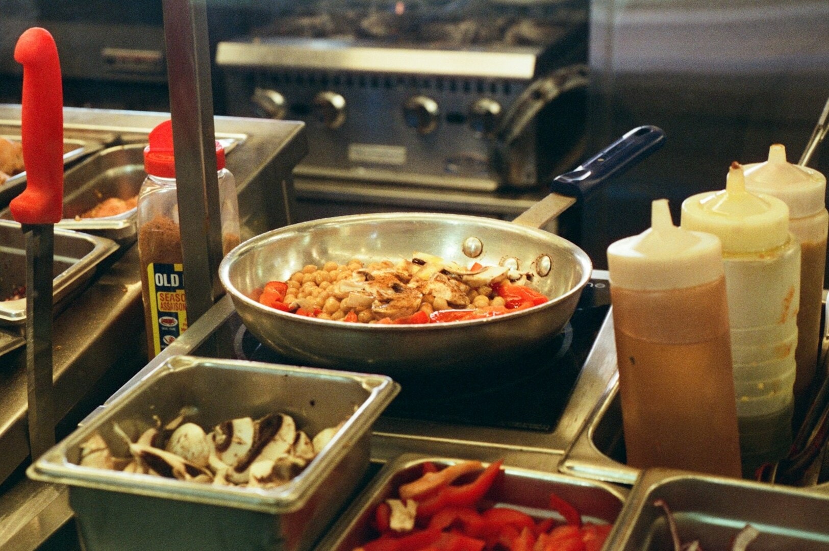 A bustling kitchen at a Singapore Hawker Centre, showcasing an array of delicious food items and vibrant culinary activity.