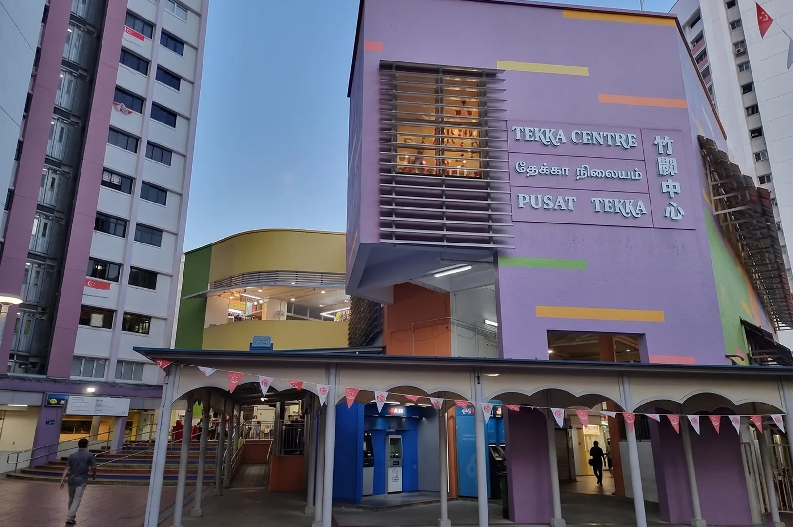 The colorful purple and yellow exterior of Tekka Centre in Little India, Singapore, a famous landmark known for its wet market and hawker centre.