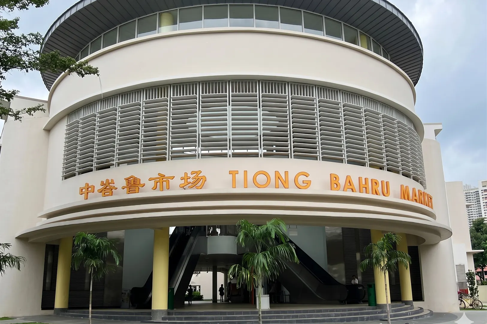 The modern circular facade and main entrance of Tiong Bahru Market and Hawker Centre in Singapore.