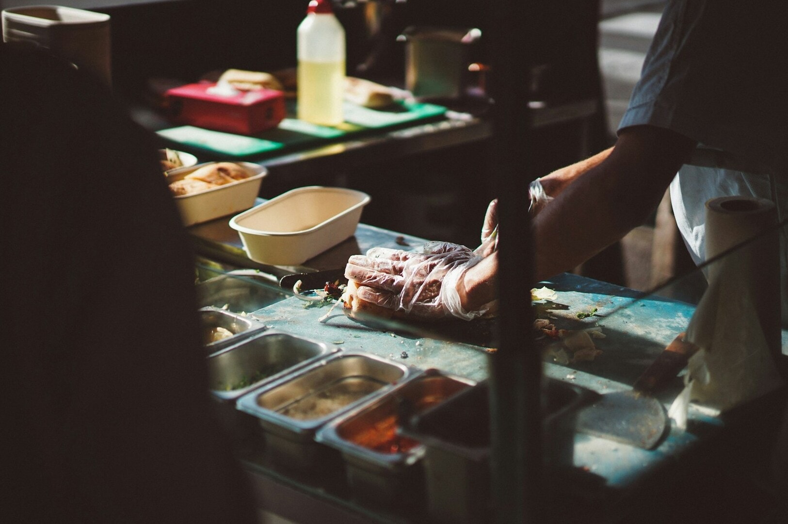 In a Singapore Hawker Centre, a person skillfully prepares food, showcasing vibrant ingredients and traditional cooking methods.
