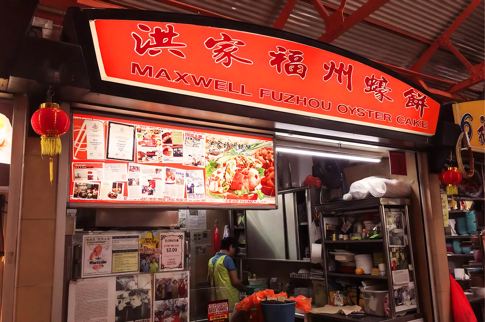 Red and orange food stall at Maxwell Market, labeled "Maxwell Fuzhou Oyster Cake." A person works inside. Menus and images fill the display.