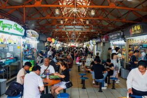 Crowded Maxwell Hawker Centre, showcasing people dining and shopping amidst vibrant market stalls and lively atmosphere. Photo by DelightfulTravelNotes.