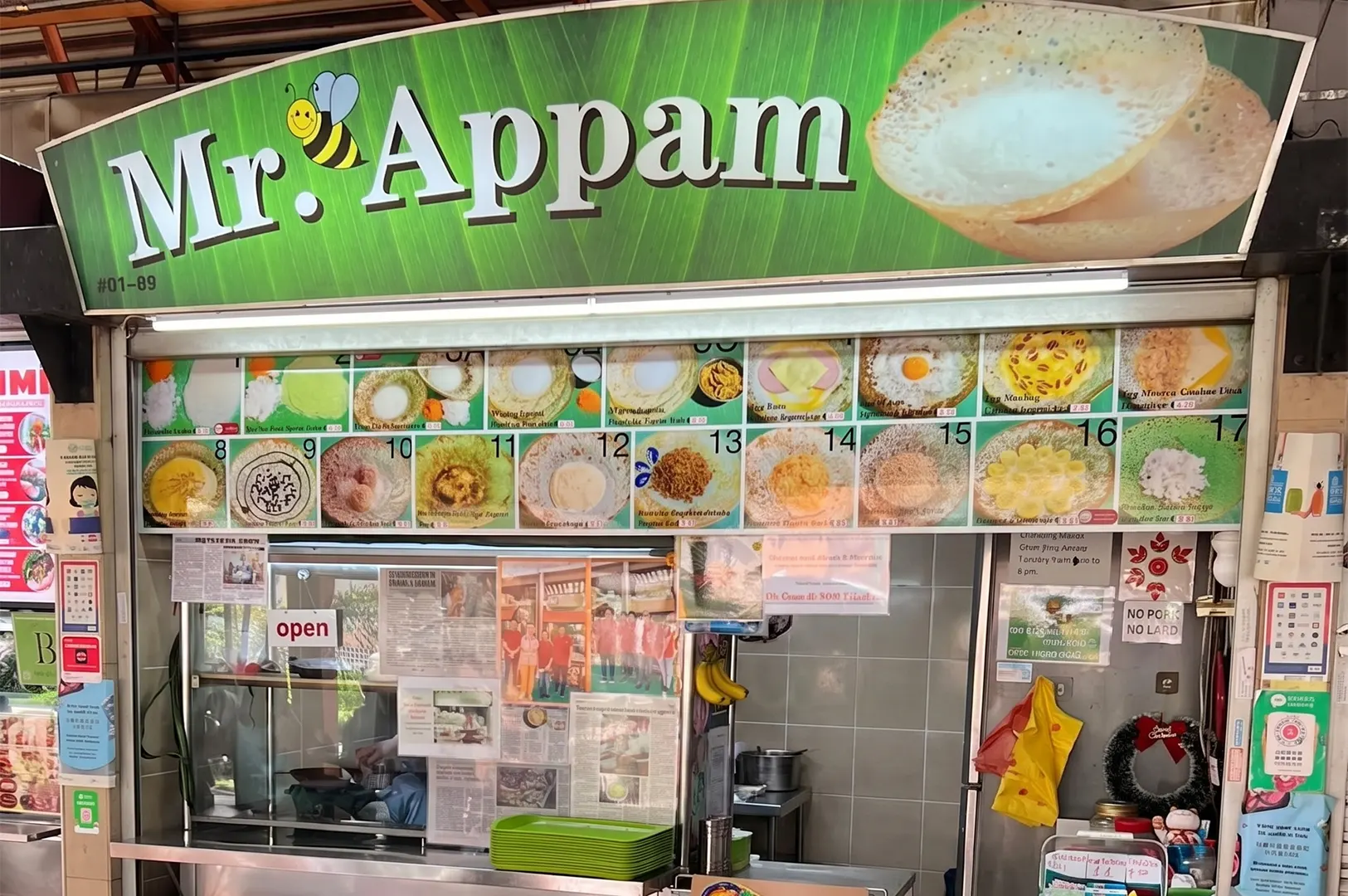 Mr. Appam hawker stall storefront with a green sign and illustrated menu displaying varieties of Indian appam pancakes.
