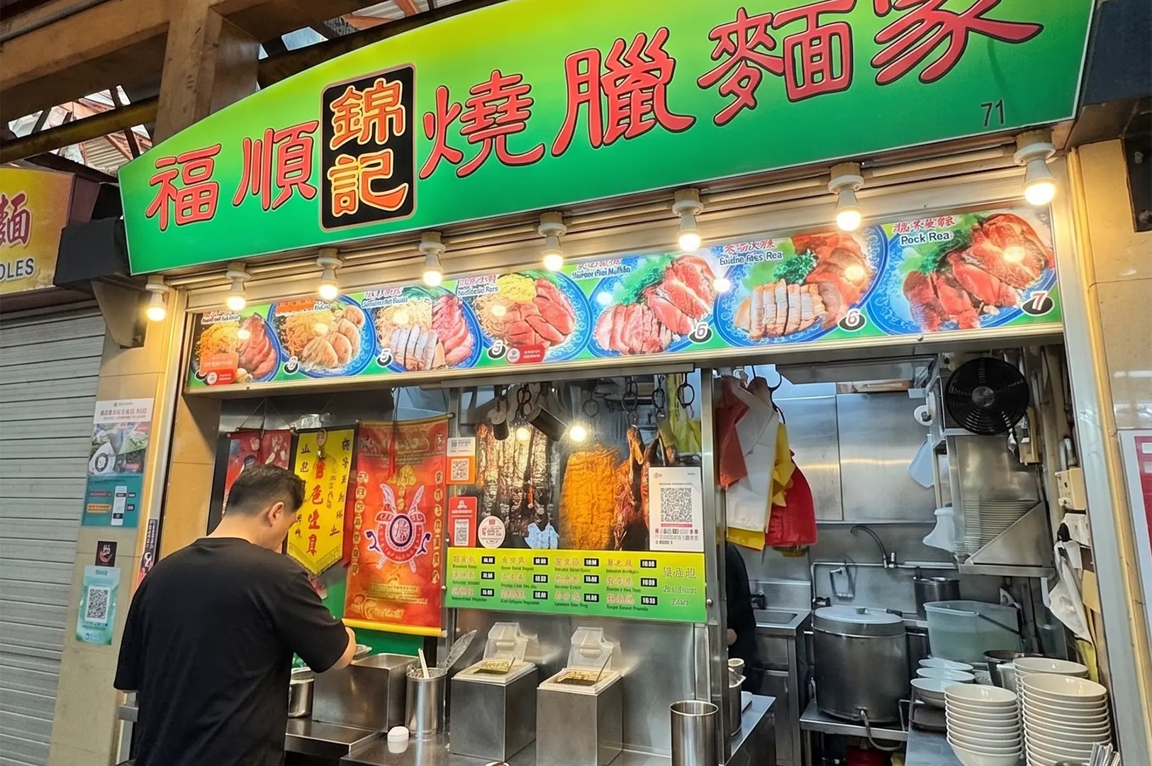 Fu Shun Jin Ji Roasted Meat Specialist hawker stall storefront with a bright green sign, hanging roasted meats, and a customer ordering.