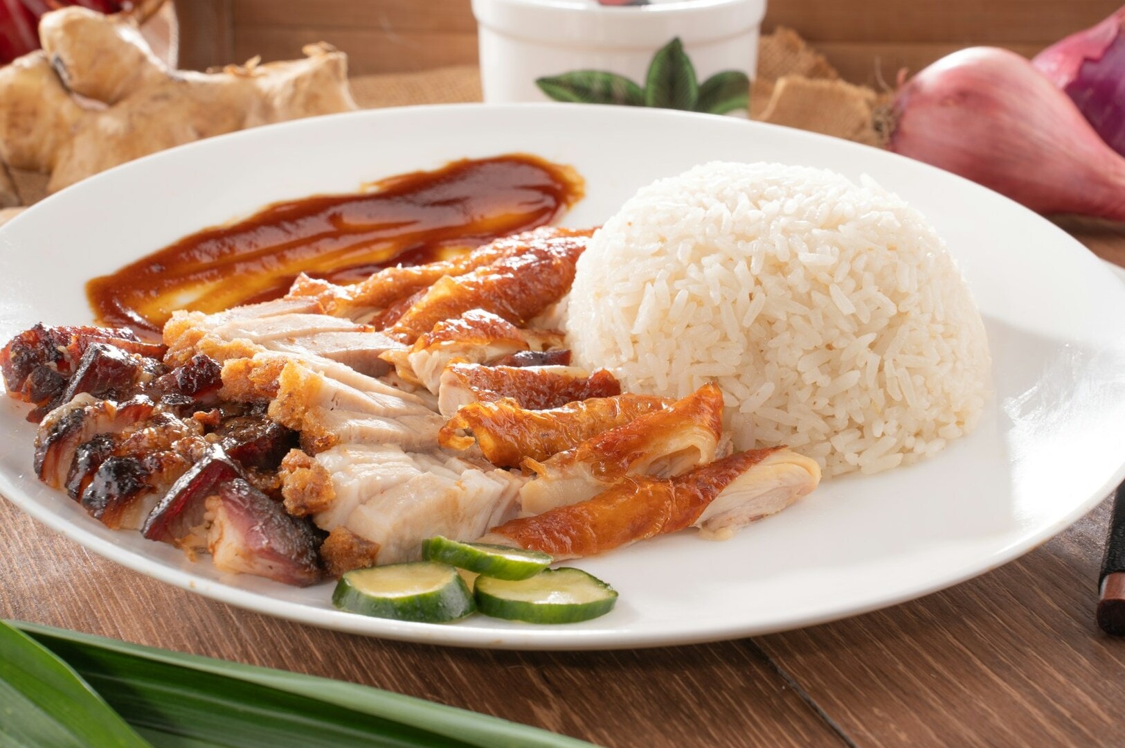 Hainanese chicken rice served on a plate, showcasing succulent chicken and fluffy rice at Maxwell Hawker Centre.
