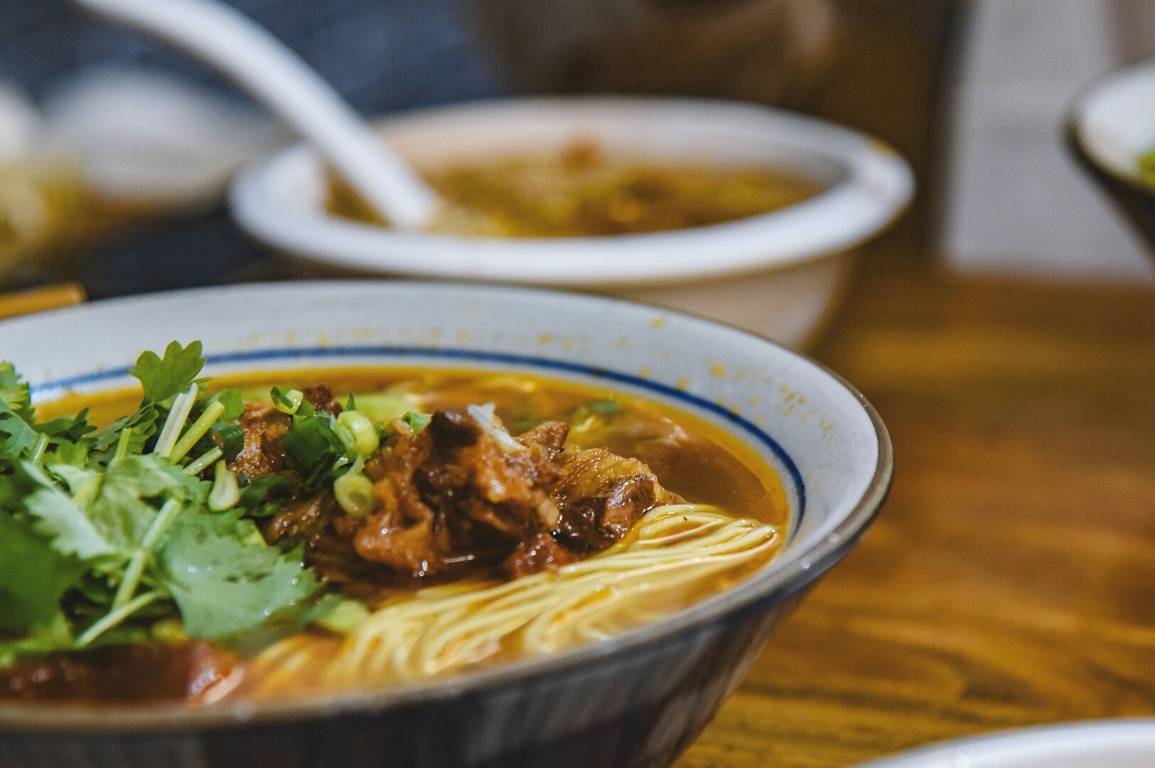 A bowl filled with noodles, meat, and vegetables, presented at Golden Mile Food Centre.