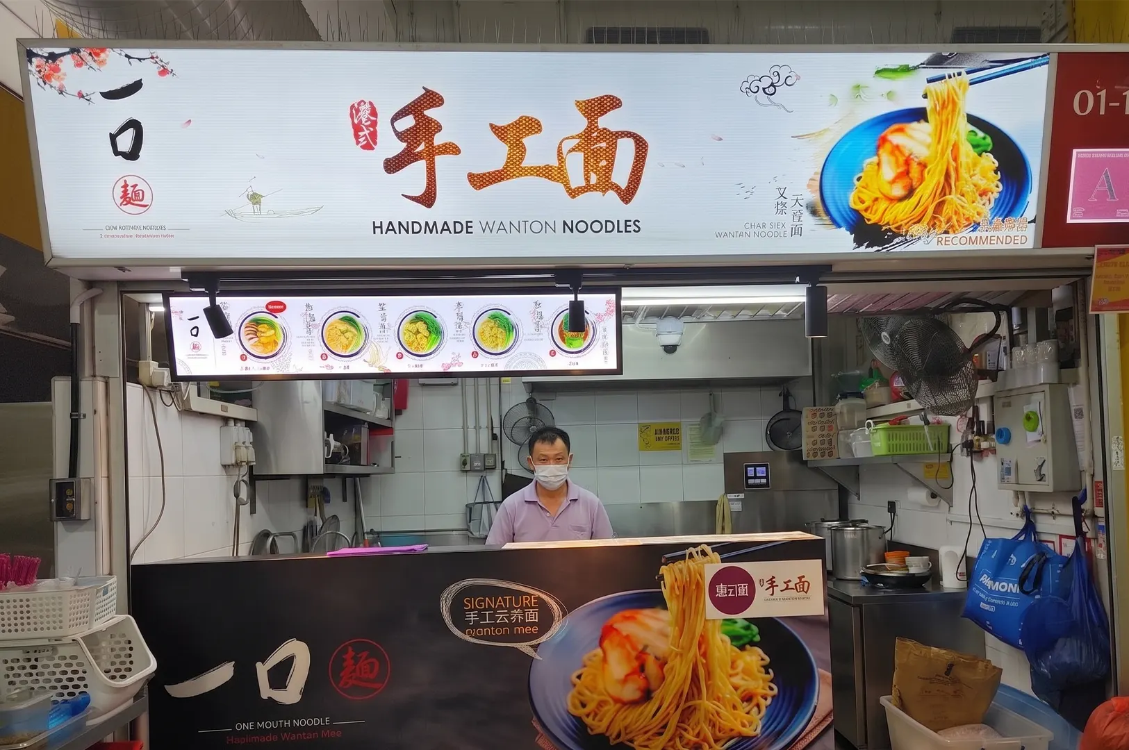 Handmade Wanton Noodles hawker stall with a vendor standing behind the counter.