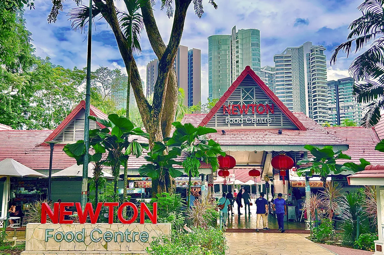 Newton Food Centre entrance with red roof, lush greenery, and skyscrapers in the background. People walking inside, vibrant and bustling atmosphere.