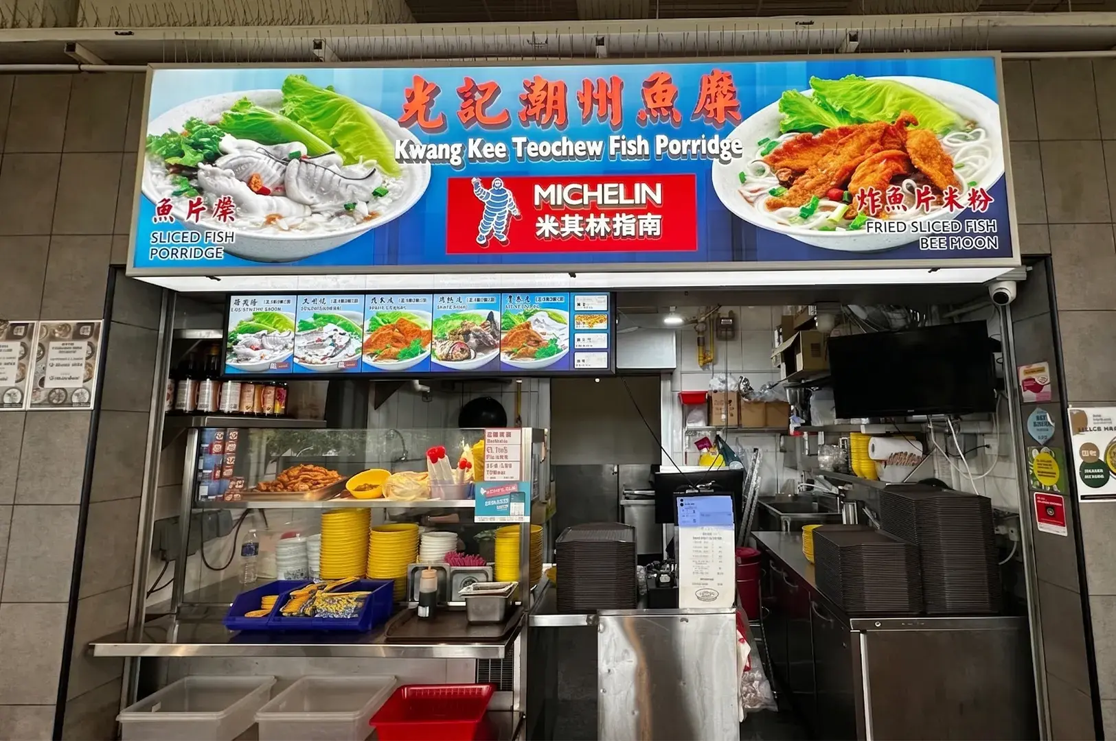 Kwang Kee Teochew Fish Porridge stall with a Michelin Guide sign, featuring sliced fish porridge and fried fish bee hoon.