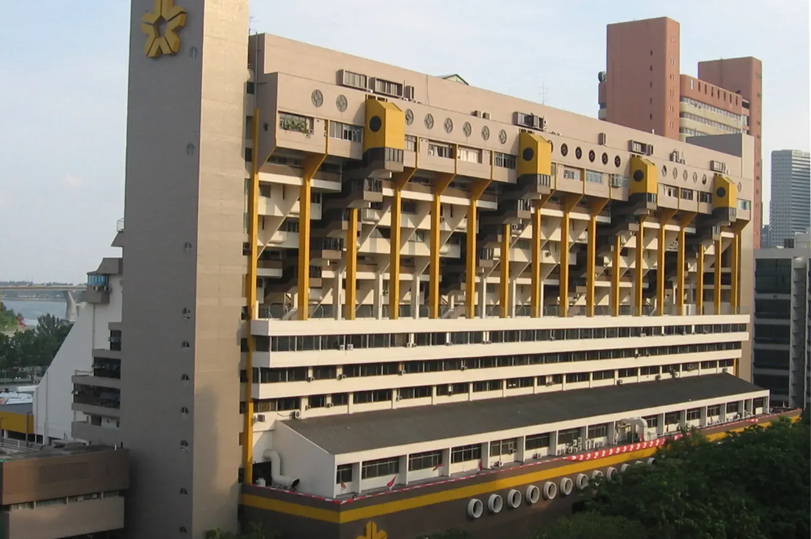 Exterior view of the Golden Mile Complex building, known for its terraced Brutalist architecture and yellow accents.