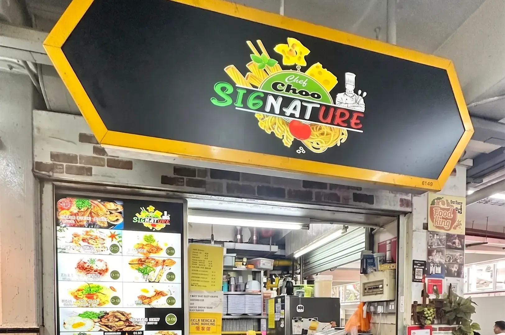 Storefront of Chef Choo Signature hawker stall with a large hexagonal sign and a visual menu board.
