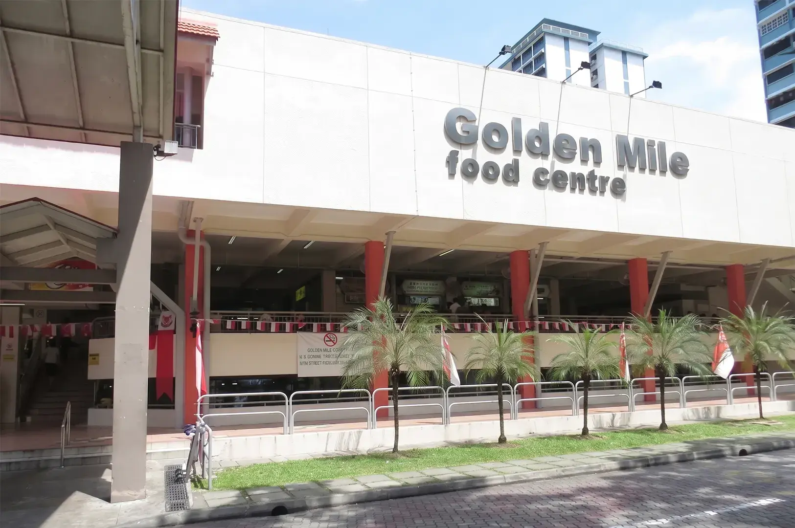 Exterior view of the Golden Mile Food Centre building under a clear sky.