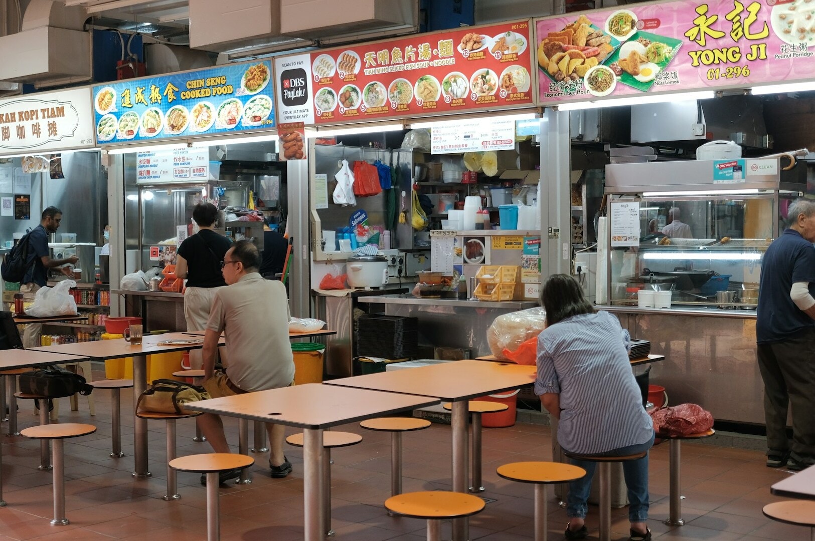 Interior view of Singapore Old Airport Road Food Centre, showcasing many tables set for patrons enjoying their meals.