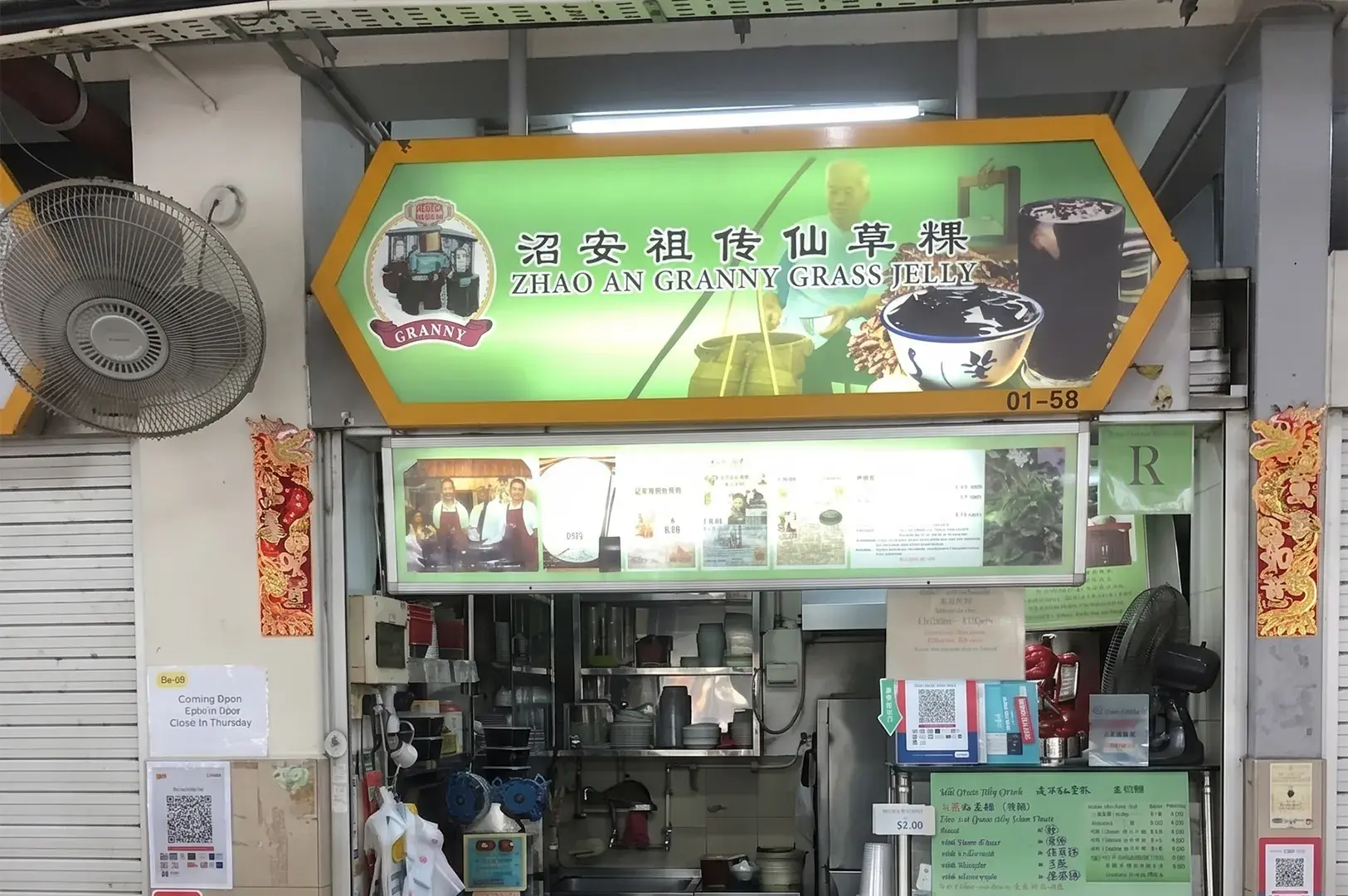 Storefront of the Zhao An Granny Grass Jelly hawker stall, featuring a green hexagonal sign and a detailed menu.