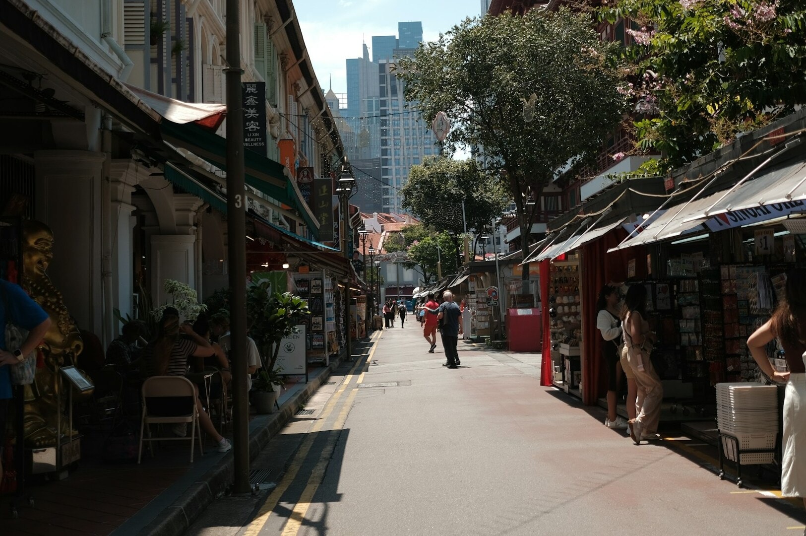 A lively street scene in Singapore featuring shops and pedestrians, showcasing hidden kaya toast gems.