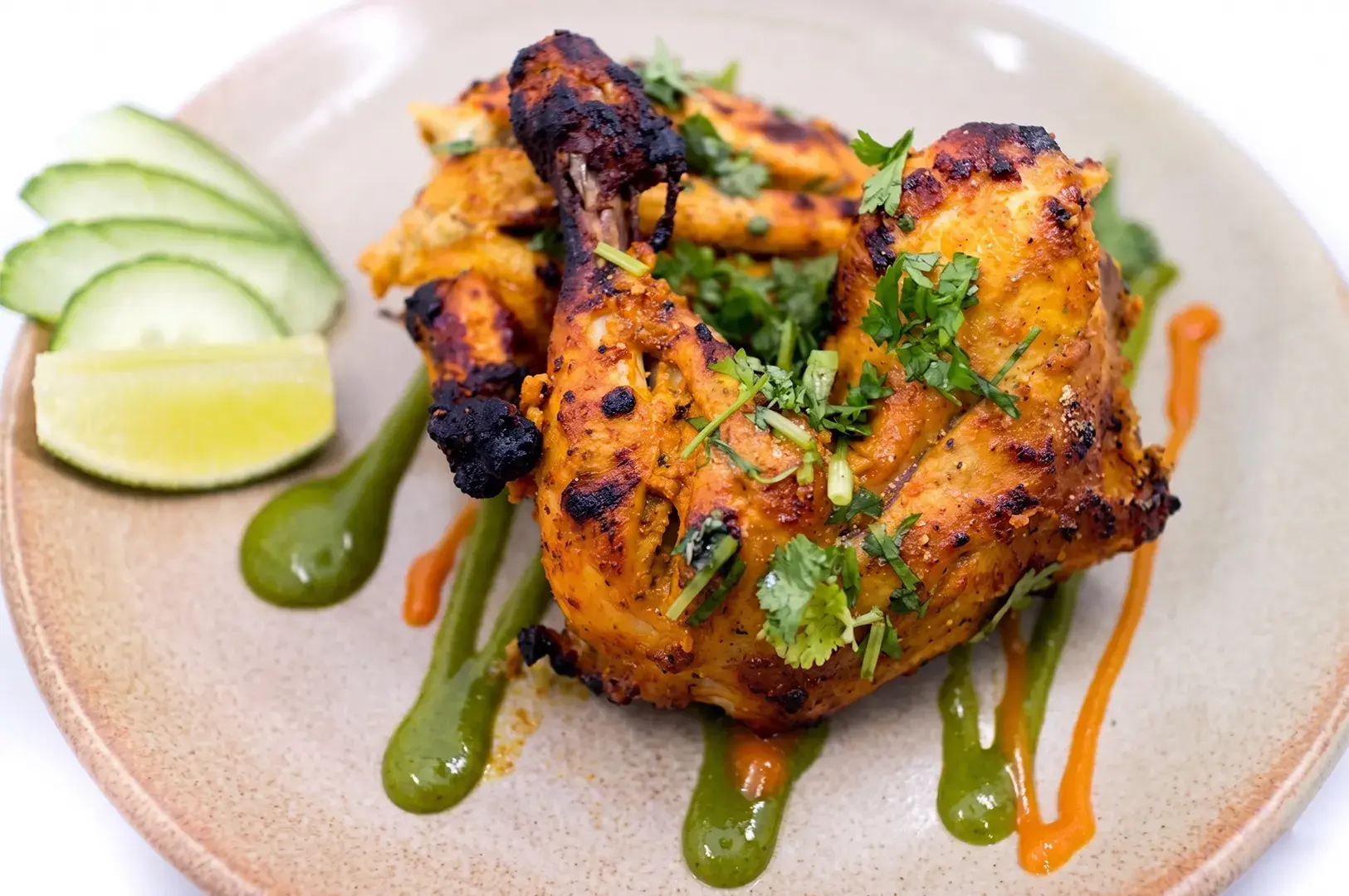 Tandoori roasted chicken leg served with cucumber, lime, and mint chutney.