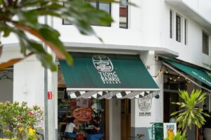 Tiong Bahru restaurant featuring a green awning and a sign.