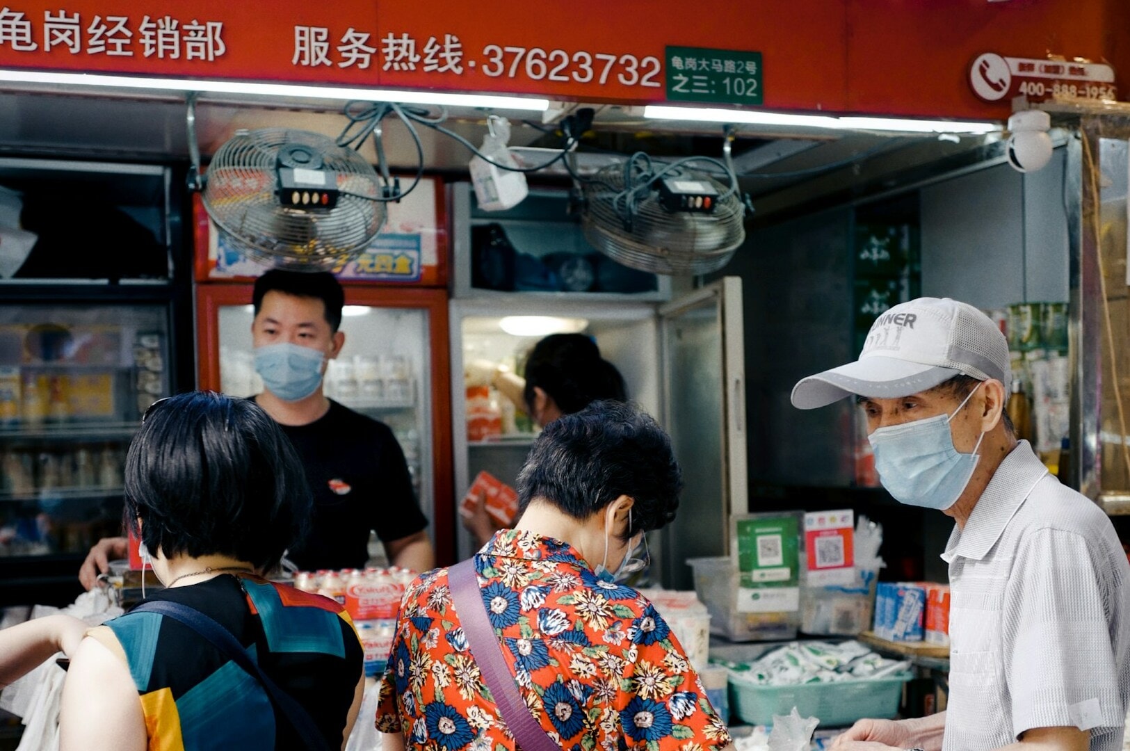 A group of individuals in face masks at a food stand in Toa Payoh’s Community, sharing a meal in a safe environment.