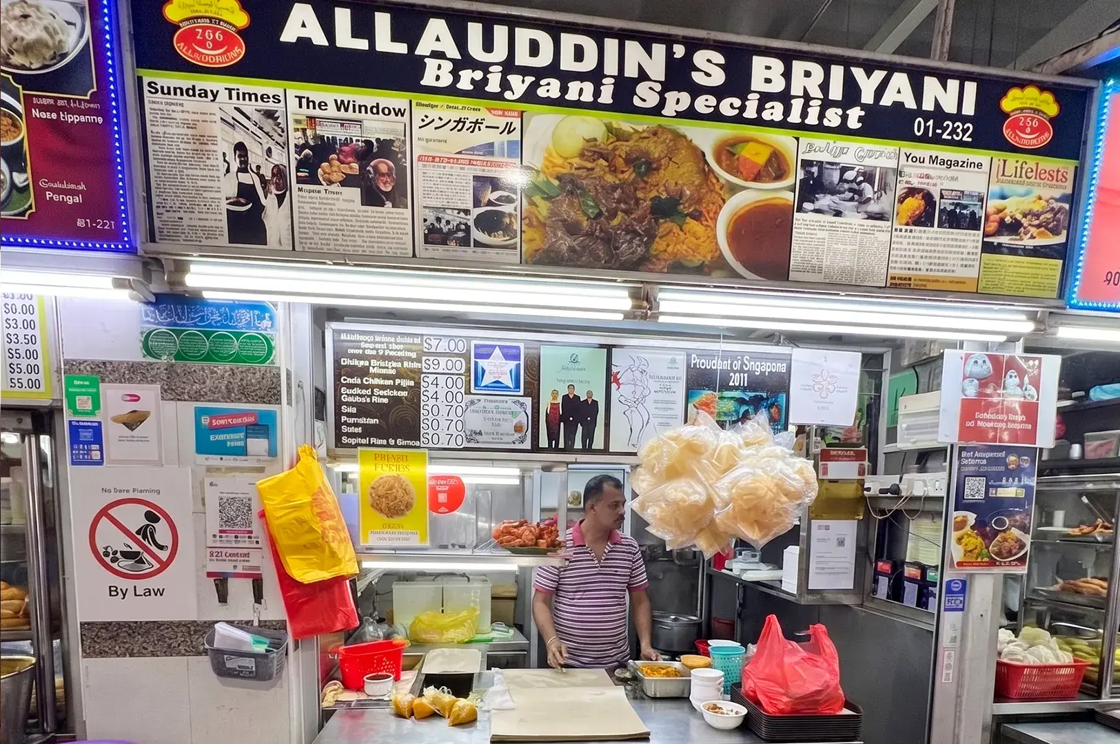 Allauddin's Briyani Specialist hawker stall at Tekka Centre in Singapore with a stall owner working at the counter.