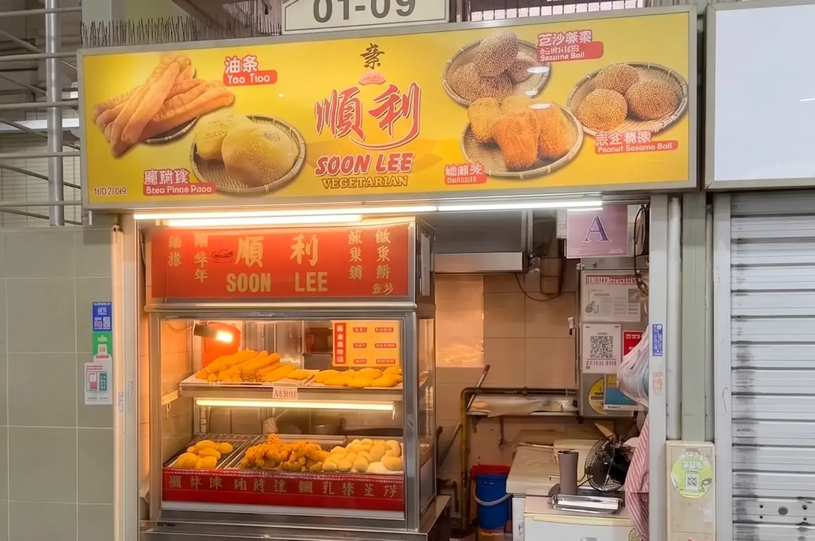 Soon Lee Vegetarian hawker stall storefront with a yellow sign displaying Chinese fried snacks like you tiao and sesame balls.