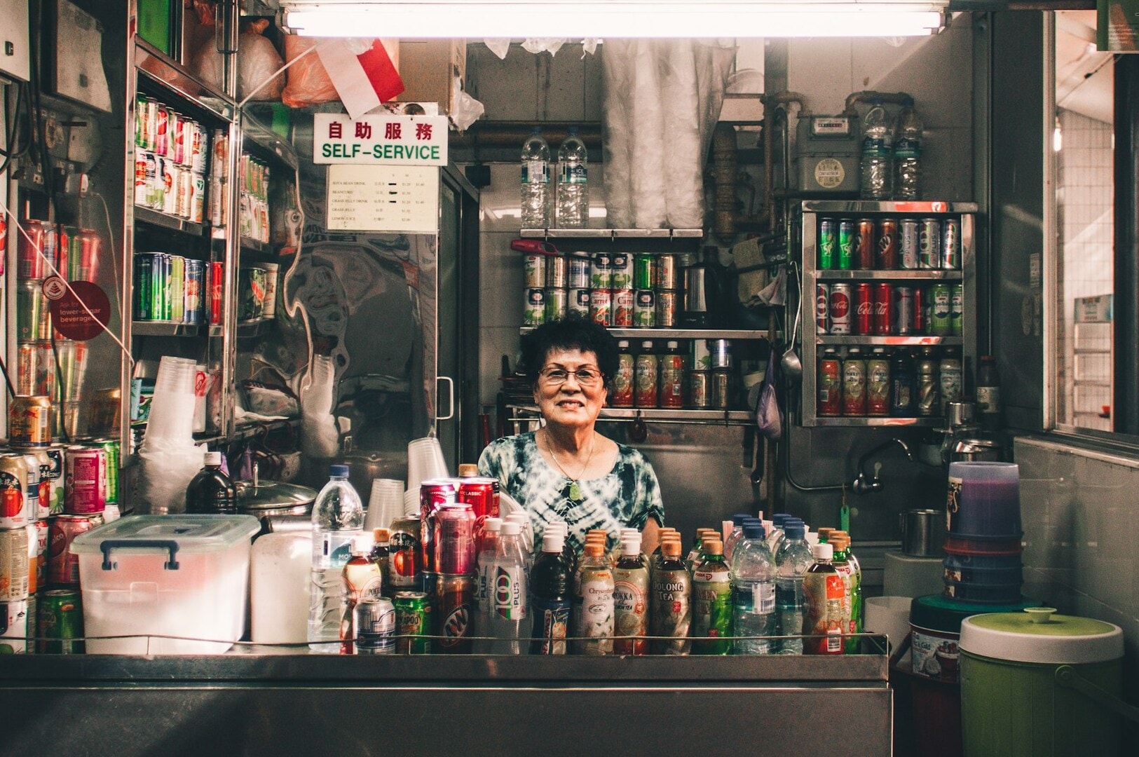 A woman stands behind the counter at Kaya Toast Spots in Singapore, ready to serve customers.