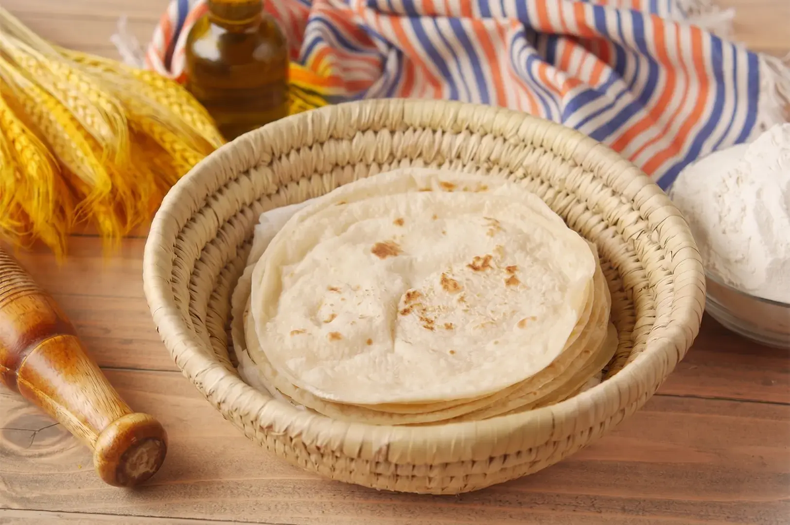 Stack of fresh homemade flatbread in a woven basket.