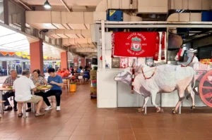 Customers browsing fresh seafood at a traditional Singapore wet market stall with Chinese New Year decorations.