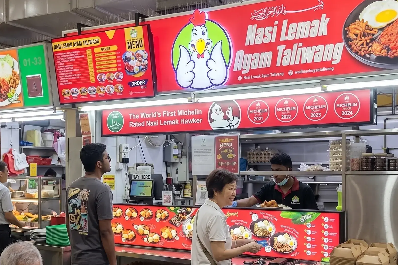 Nasi Lemak Ayam Taliwang hawker stall storefront displaying its Michelin Guide awards with customers ordering.