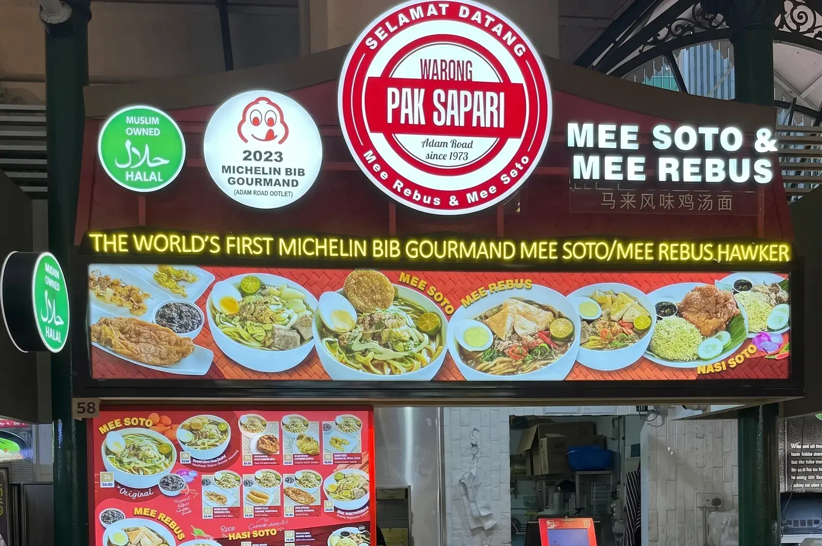 A Halal-certified hawker stall signboard for "Warong Pak Sapari" featuring Michelin Bib Gourmand badges and a visual menu of Mee Soto, Mee Rebus, and Nasi Soto.