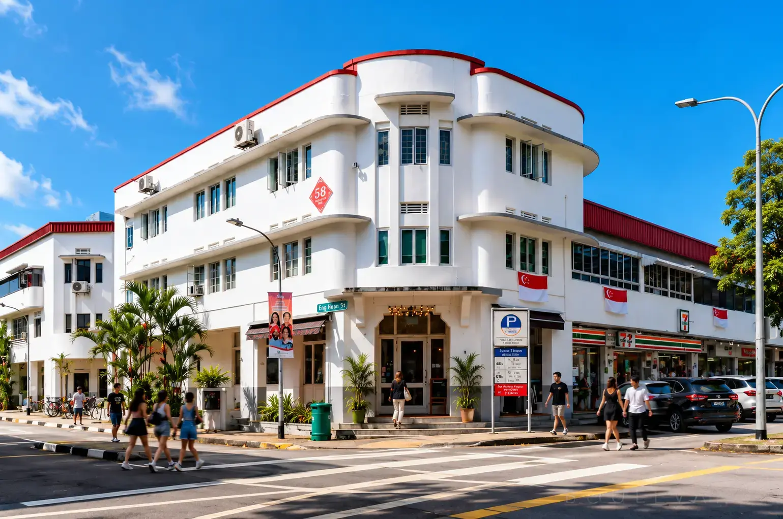 A vibrant, sunny shot of the same Art Deco-style building corner in modern times, now featuring white walls, red trim, and Singapore flags, with pedestrians using a crosswalk and a 7-Eleven store visible at street level.